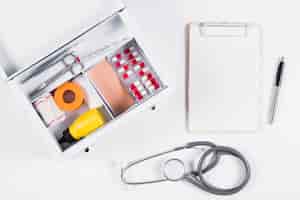 Bezpłatne zdjęcie zestaw pierwszej pomocy ze schowkiem; stetoskop i pióro na białym tle