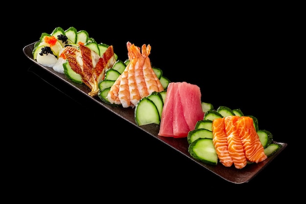 Zestaw sashimi z surowym tuńczykiem z łososia z grilla z mątwy unagi i tobiko na czarnym tle