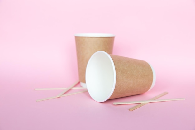 Zestaw z jednorazowymi, ekologicznymi naczyniami papierowymi na różowym tle