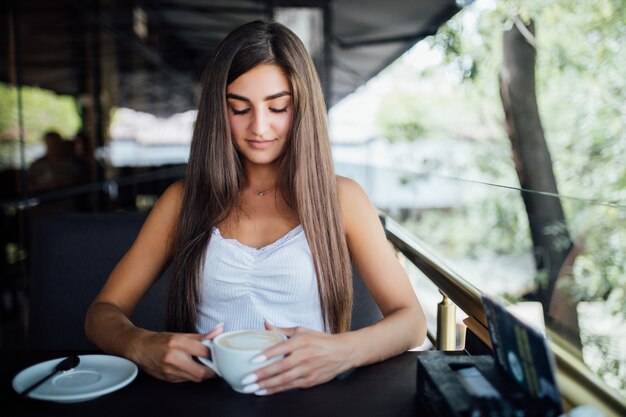 Zewnątrz moda portret pięknej młodej dziewczyny picia herbaty kawy