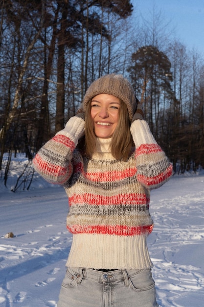 Bezpłatne zdjęcie zewnątrz portret młodej pięknej modnej szczęśliwej uśmiechniętej kobiety portret zimowy, kobieta w czapce zimowej, śnieg. ciesząc się zimowymi chwilami
