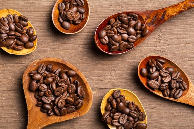 Bezpłatne zdjęcie ziarna kawy leżą płasko w drewnianych łyżkach
