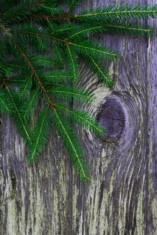 Zielone gałęzie choinki na starym drewnianym tle z pionowym zdjęciem