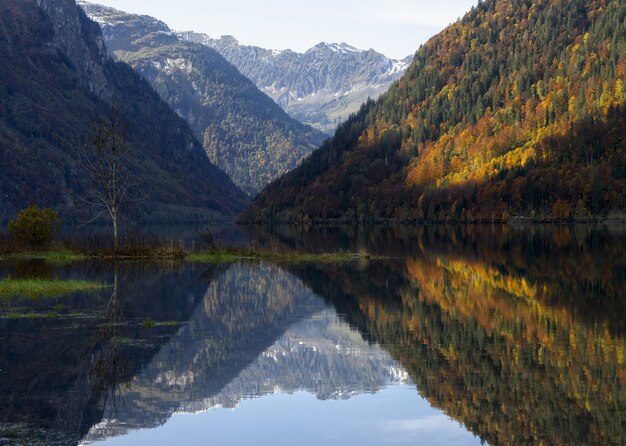 Zielone i brązowe góry nad jeziorem w ciągu dnia