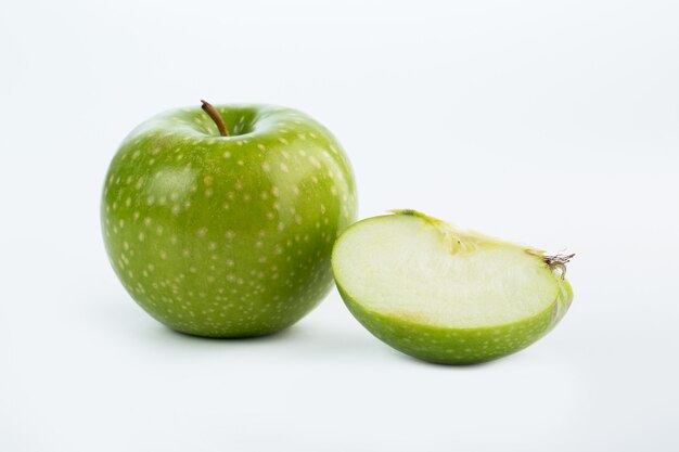 Zielony jabłczany soczysty pulchny cięcie odizolowywający na bielu