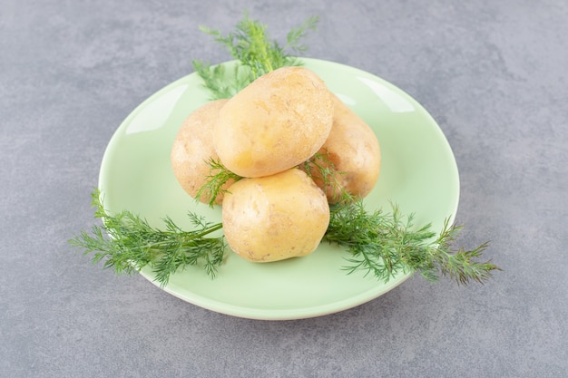 Bezpłatne zdjęcie zielony talerz niegotowanych ziemniaków ze świeżym koperkiem