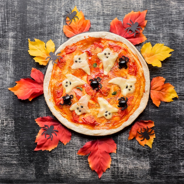 Zła pizza Halloween otoczona liśćmi