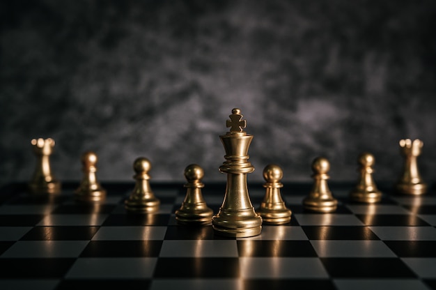 Bezpłatne zdjęcie złocisty szachy na szachowej grą planszowa dla biznesowego metafory przywódctwo pojęcia