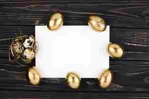 Bezpłatne zdjęcie złote i przepiórcze jaja wokół arkusza papieru