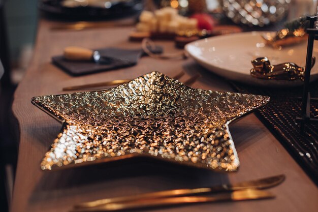 Złoty talerz w kształcie gwiazdy na stole noworocznym. Koncepcja sylwestrowa