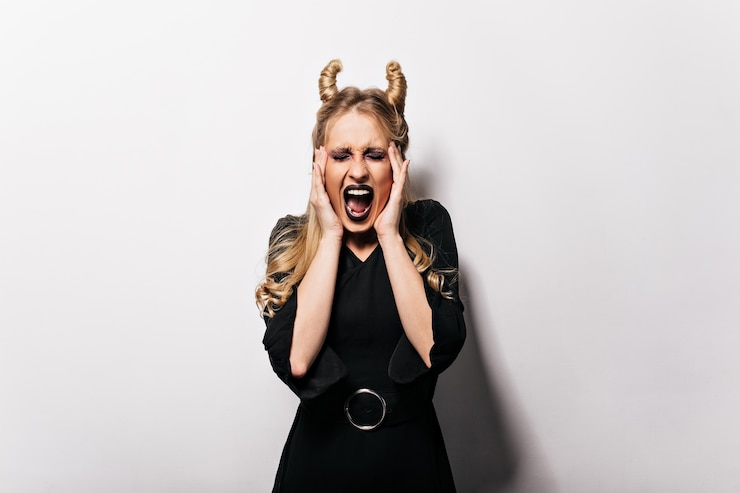 Bezpłatny plik Zdjęcie zły wampir z długimi włosami pozowanie w halloween. blondynka krzyczy na karnawałową sesję zdjęciową.