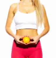 Bezpłatne zdjęcie zmysłowy portret pięknej sportowej młodej dziewczyny fitness kobiety z idealnym ciałem witn pomarańczy