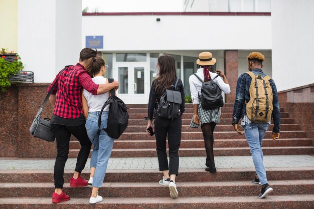 Znajomi chodząc po schodach na uniwersytet