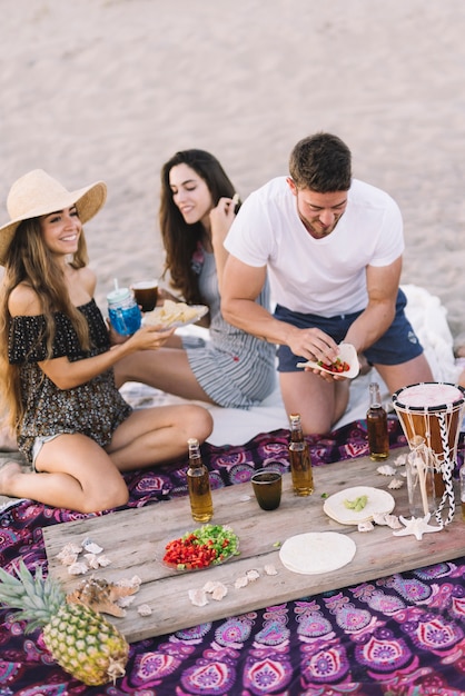 Bezpłatne zdjęcie znajomi na plaży z napojami na desce