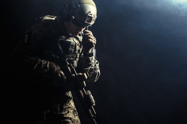 Żołnierz sił specjalnych z karabinem w ciemności