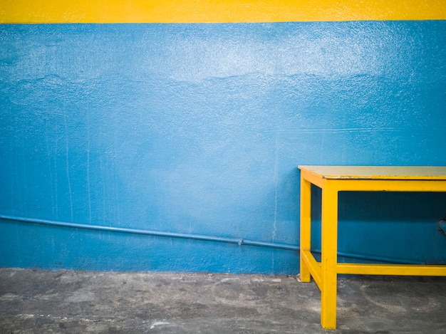 Żółta ławka przeciw błękitnej ścianie