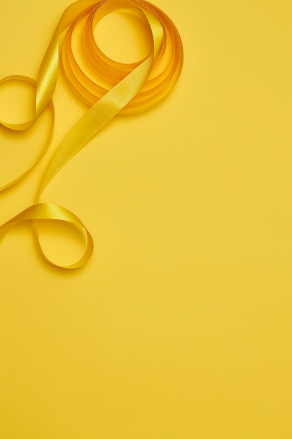 Bezpłatne zdjęcie Żółta wstążka na żółtawym tle