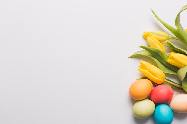 Bezpłatne zdjęcie Żółte tulipany i kolorowe jajka