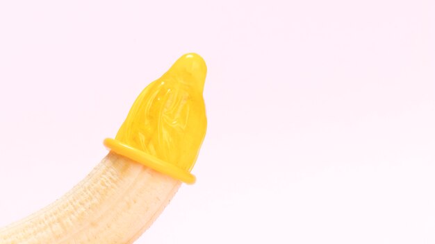 Żółty rozpakowany kondom na banana