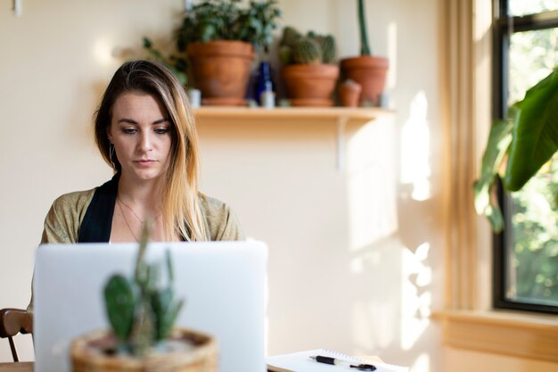 Zrelaksowana kobieta pracująca w domu na swoim laptopie