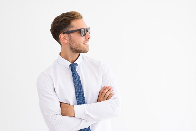 Zrelaksowany biznesowy mężczyzna jest ubranym okulary przeciwsłonecznych i patrzeje daleko od