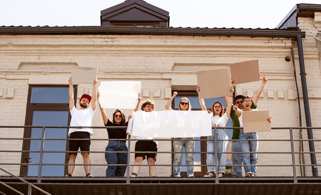 Zróżnicowana grupa ludzi protestujących pustymi znakami. Protest przeciwko prawom człowieka, nadużywaniu wolności, problemom społecznym