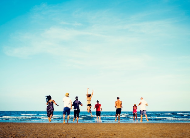 Zróżnicowana grupa przyjaciół biegnących na plażę