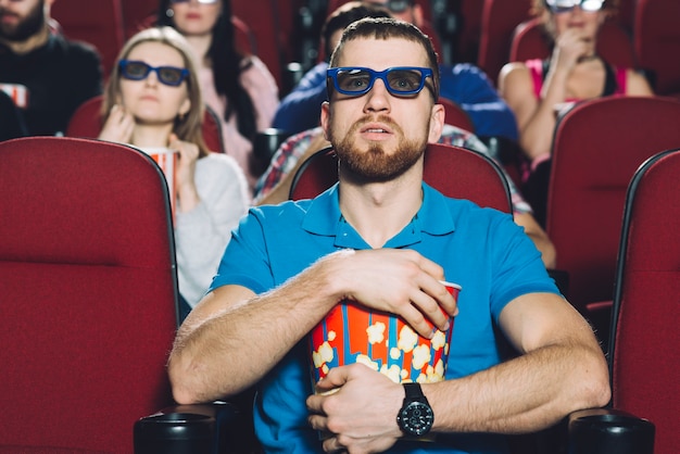 Zszokowany mężczyzna ogląda film w kinie