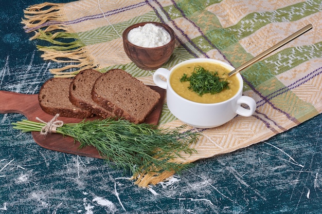 Bezpłatne zdjęcie zupa jarzynowa z ziołami i przyprawami podawana z kromką grzanki.