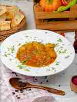 Bezpłatne zdjęcie zupa z soczewicy z sosem ziemniaczano-pomidorowym i warzywami, podawana z lawą w białym talerzu