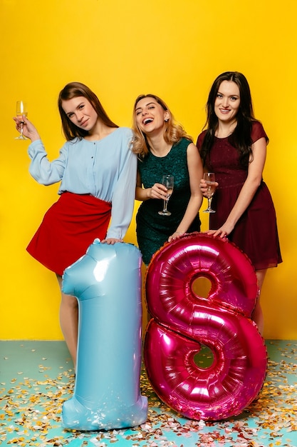 Foto gratuita 18º aniversario del feliz cumpleaños. emociones alegres de tres jóvenes chicas impresionantes divirtiéndose