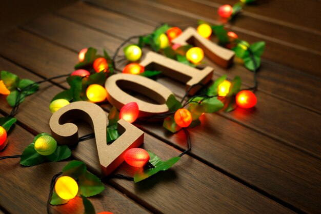 2017 Feliz Año Nuevo, figuras de madera y luces intermitentes en el escritorio retro