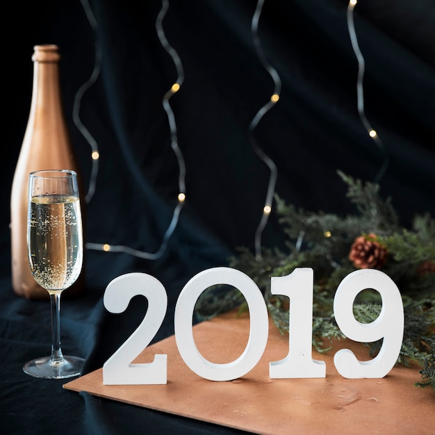 Foto gratuita 2019 inscripción con copa de champagne en mesa