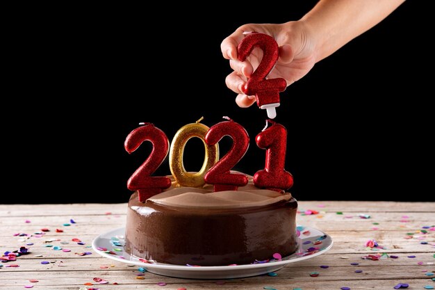 2022 tarta y adornos sobre mesa de madera y fondo negro