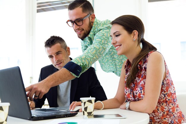 Foto gratuita 3 jóvenes trabajadores en la oficina