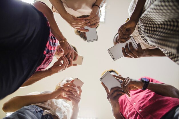 Desde abajo foto de estudiantes con teléfonos