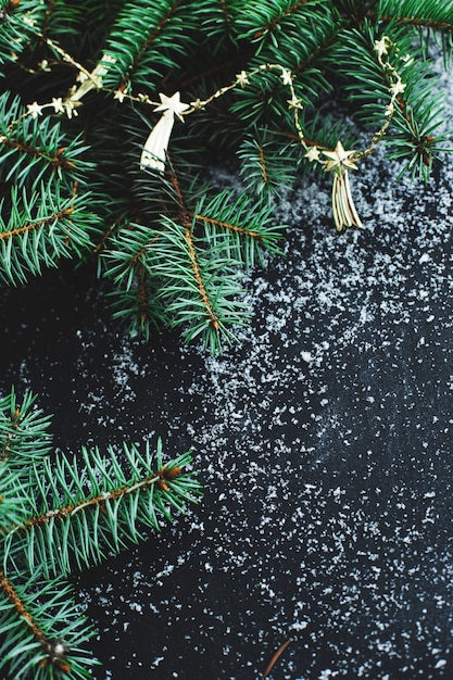 Abeto de Navidad en la superficie oscura con nieve