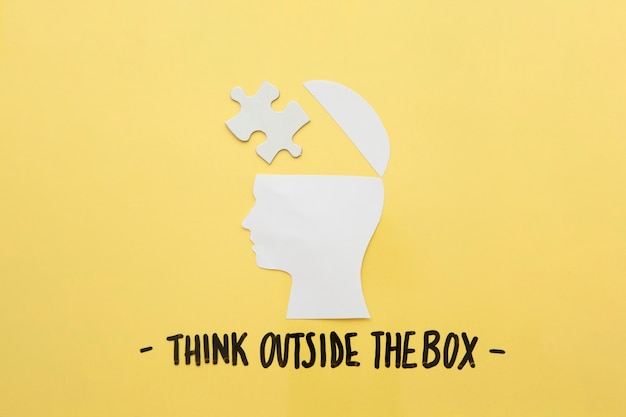 Abra el cerebro humano con la pieza del rompecabezas cerca de pensar el mensaje fuera de la caja