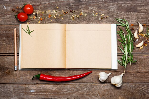 Abra el libro de recetas en blanco sobre fondo de madera marrón