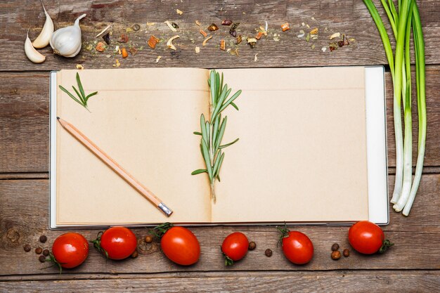 Abra el libro de recetas en blanco sobre fondo de madera marrón