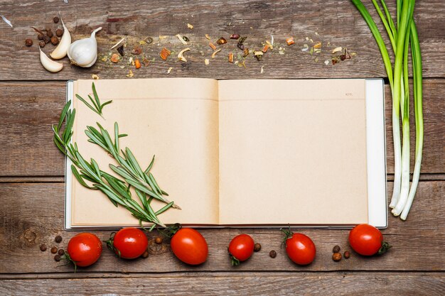 Abra el libro de recetas en blanco sobre fondo de madera marrón