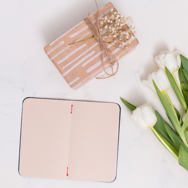 Abra la tarjeta en blanco; Caja de regalo con flores de tulipán sobre fondo blanco