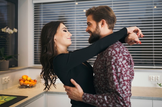 Foto gratuita abrazando alegre pareja en la cocina