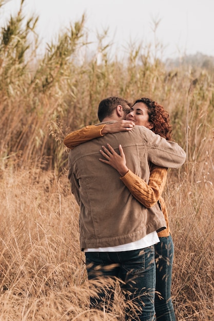 Foto gratuita abrazando pareja en campo de trigo