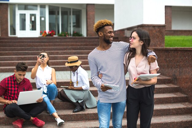 Abrazar a amigos en las escaleras de la universidad