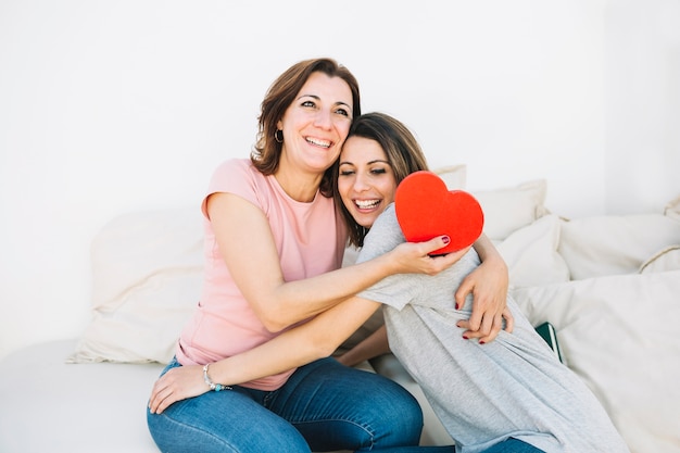 Abrazar a las mujeres con caja en forma de corazón