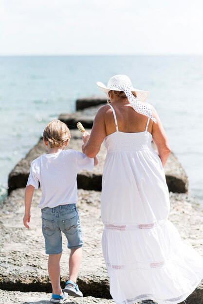 Abuela completa y niño en la playa.