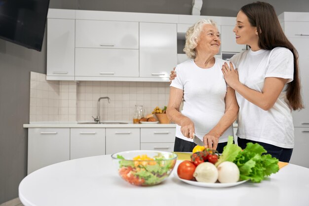 Abuela feliz y nieta cocinando juntas