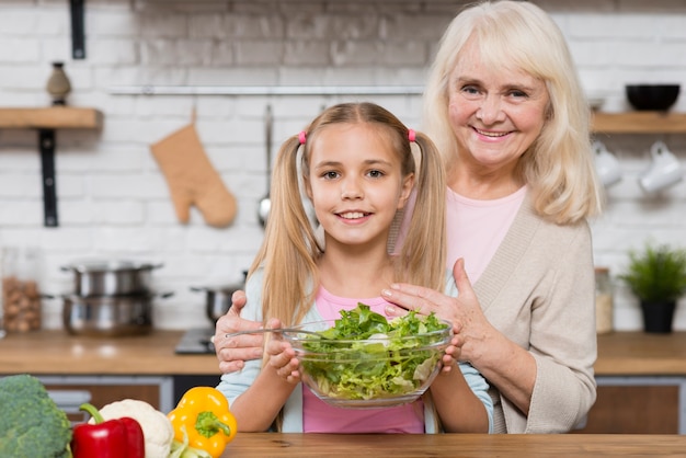 Abuela y nieta sosteniendo una ensalada