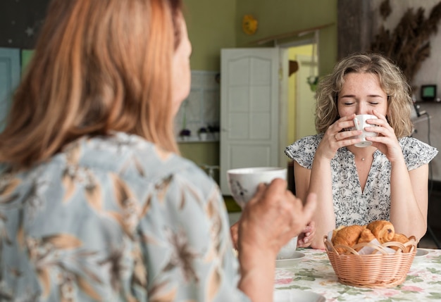 Abuela y nieta tomando café durante el desayuno